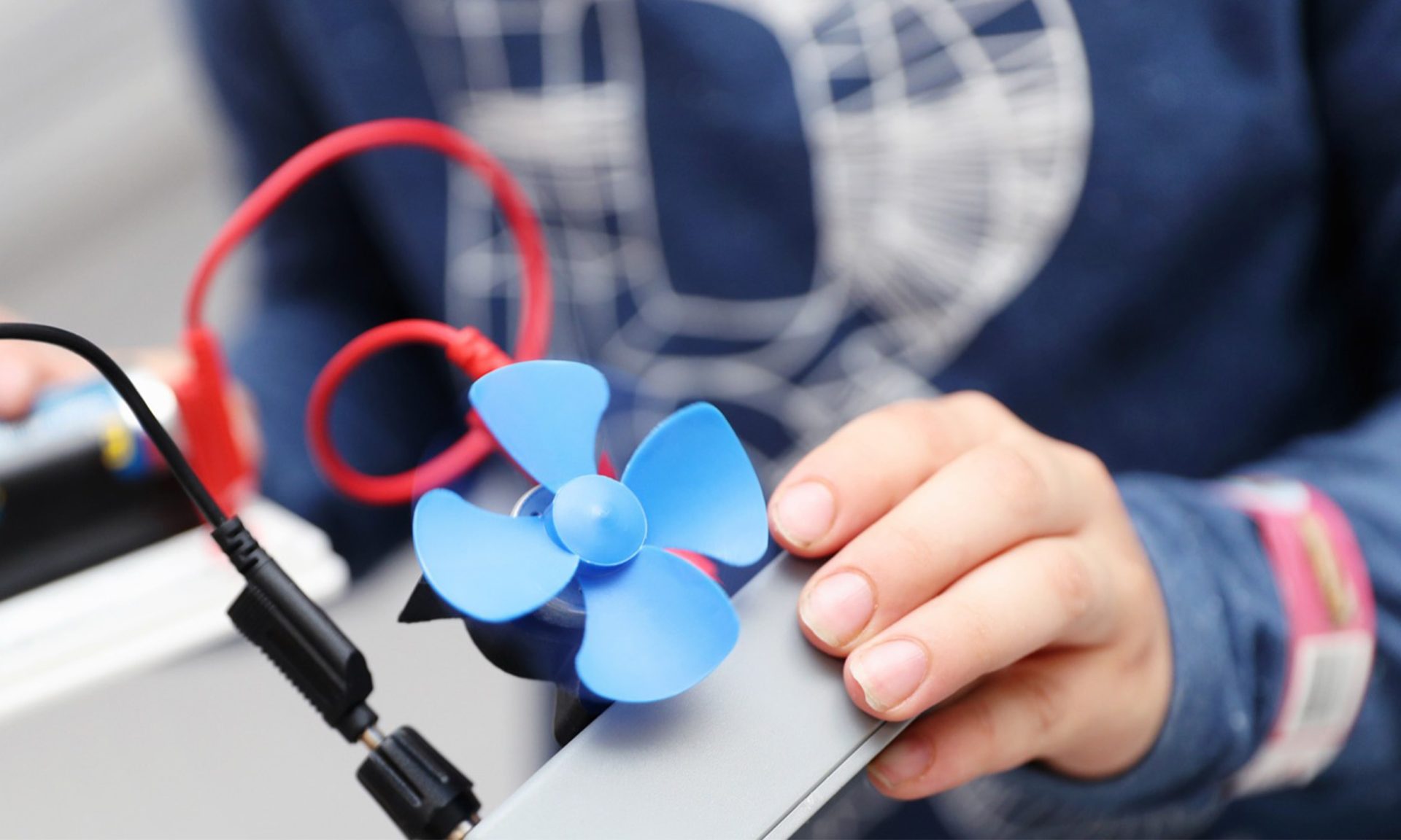 Henkilöllä on kädessään jonkinmoinen tuuletin.